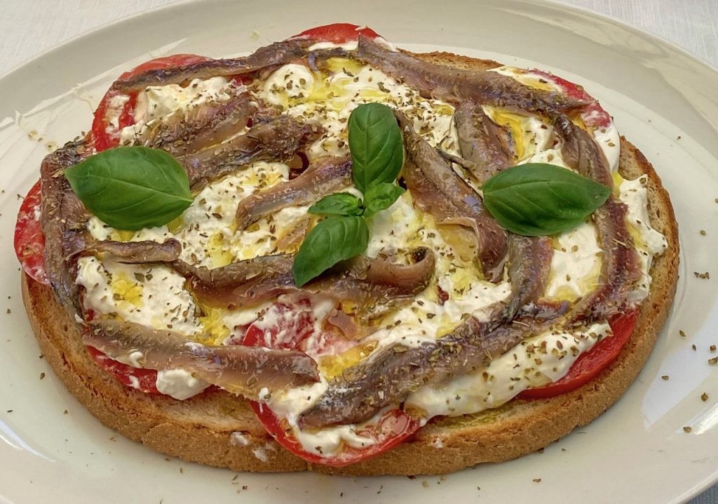 Bruschetta with tomatoes, burrata, anchovies and lemon in Vernazza - Italy