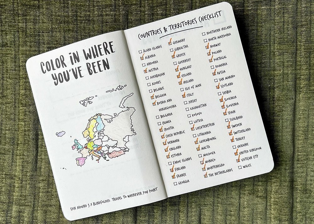 Two pages in travel journal The Adventure Book - Europe edition where someone colored in the countries they've been to on a map of Europe.